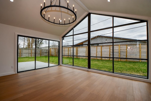 unfurnished sunroom featuring lofted ceiling with beams and a chandelier