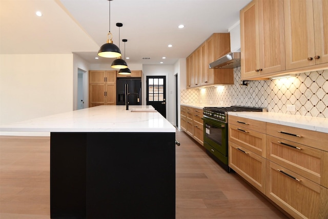 kitchen with backsplash, extractor fan, light wood-style flooring, black appliances, and a sink