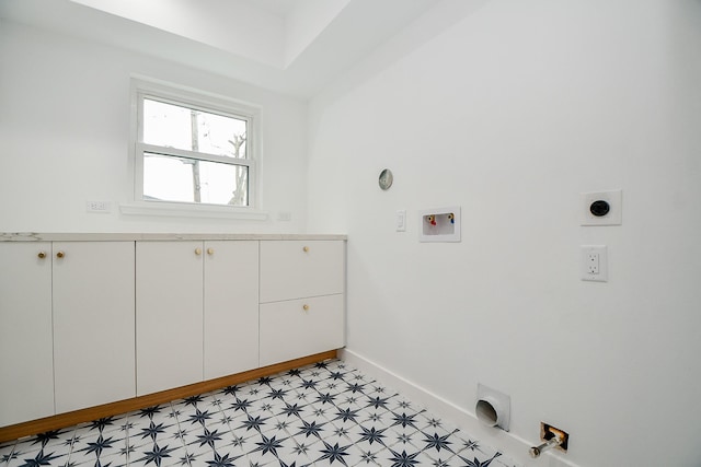 washroom featuring baseboards, light floors, hookup for a gas dryer, cabinet space, and hookup for an electric dryer