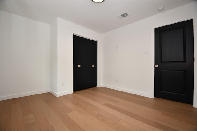 unfurnished bedroom featuring visible vents, light wood-style flooring, and baseboards