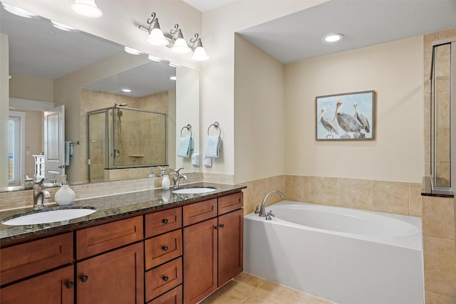 bathroom featuring tile patterned flooring, a garden tub, a stall shower, and a sink