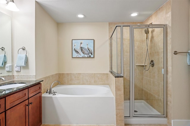 bathroom featuring recessed lighting, a stall shower, vanity, and a garden tub