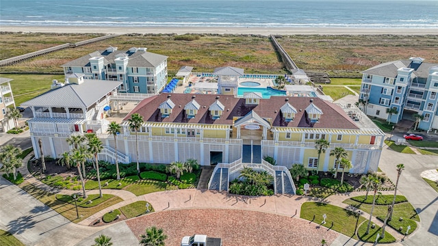 drone / aerial view featuring a residential view, a view of the beach, and a water view