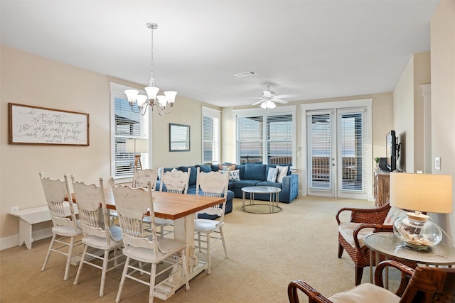 dining room featuring carpet flooring, ceiling fan with notable chandelier, visible vents, and baseboards