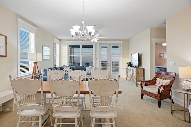 dining space featuring ceiling fan with notable chandelier and carpet floors