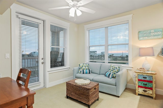 living room with baseboards, a ceiling fan, and carpet floors