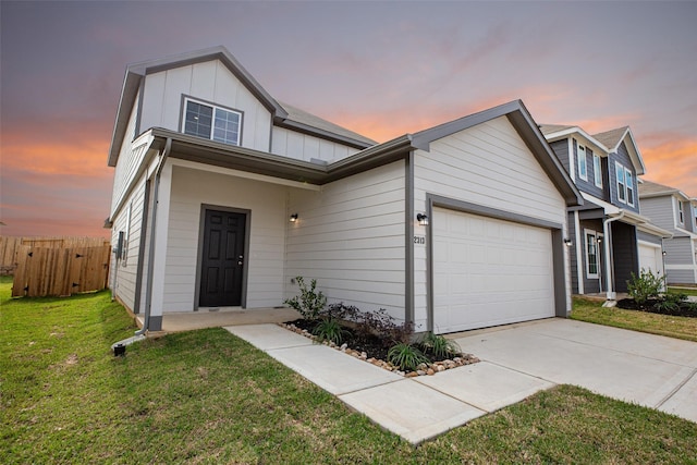 traditional-style home featuring board and batten siding, fence, a front yard, a garage, and driveway