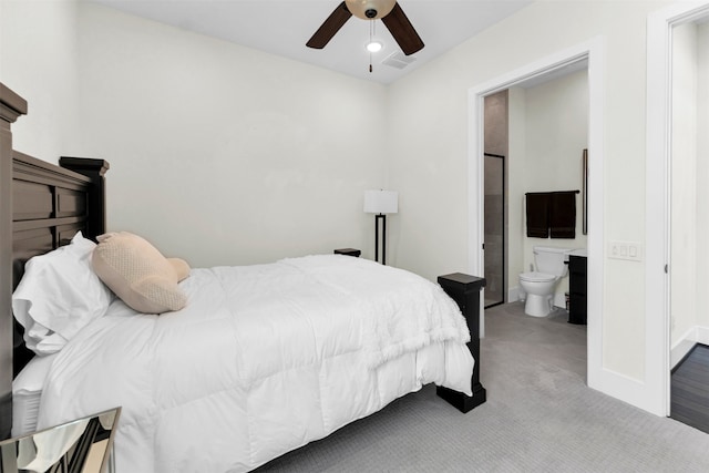 carpeted bedroom featuring ceiling fan, visible vents, baseboards, and ensuite bath