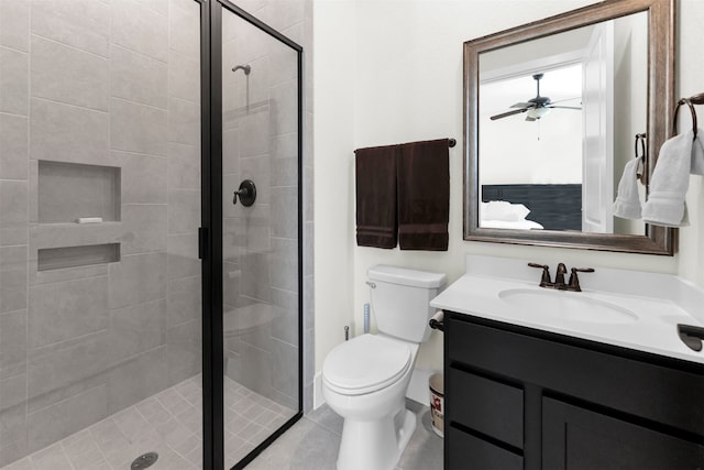 bathroom featuring vanity, a stall shower, ceiling fan, tile patterned flooring, and toilet