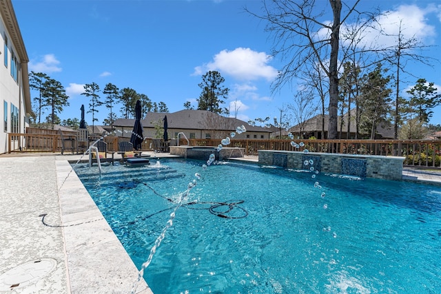 view of swimming pool with a patio area, a pool with connected hot tub, and a fenced backyard