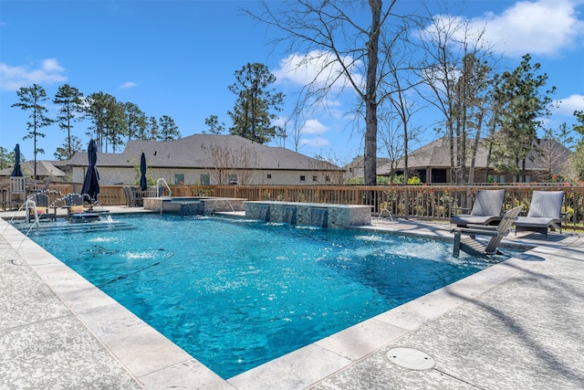 view of swimming pool featuring a pool with connected hot tub, a patio, and fence