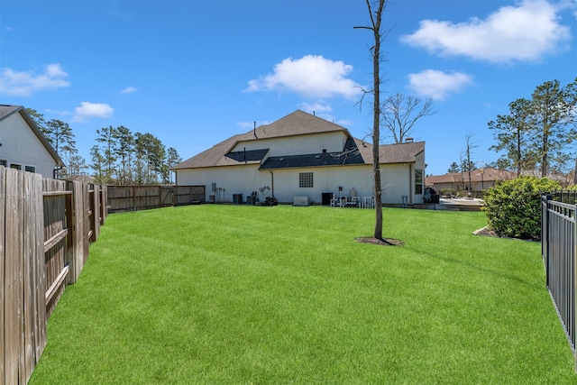 back of house featuring a yard and a fenced backyard