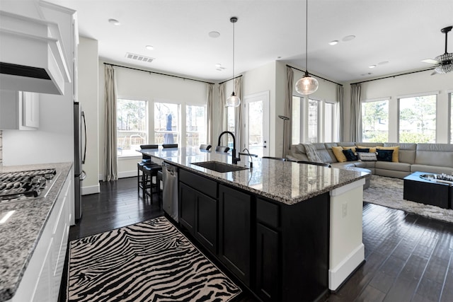 kitchen featuring a wealth of natural light, visible vents, a sink, dark cabinetry, and stainless steel appliances