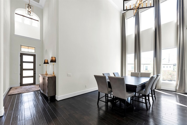 dining space with dark wood-style floors, plenty of natural light, and crown molding