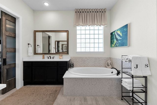 full bath with vanity and a garden tub