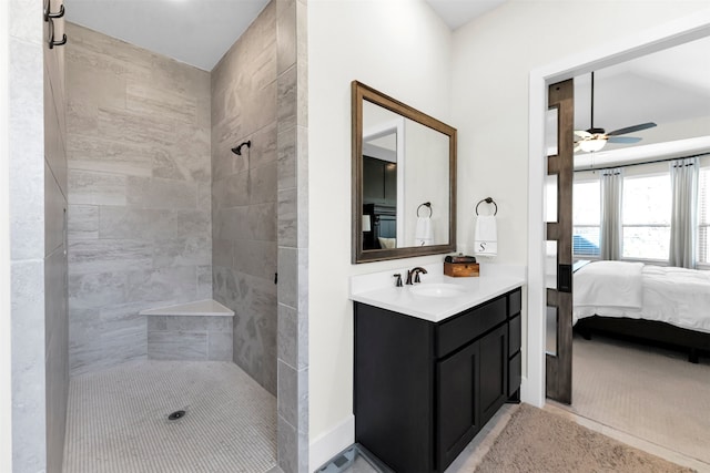 full bath with baseboards, ceiling fan, tiled shower, ensuite bathroom, and vanity