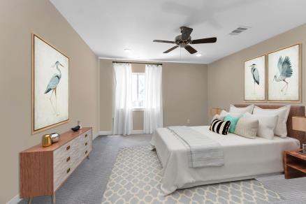 carpeted bedroom featuring a ceiling fan, visible vents, and baseboards