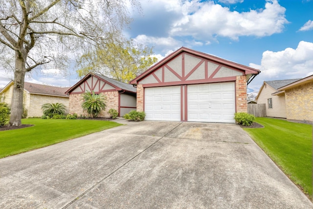 tudor home featuring stucco siding, brick siding, an attached garage, and a front yard