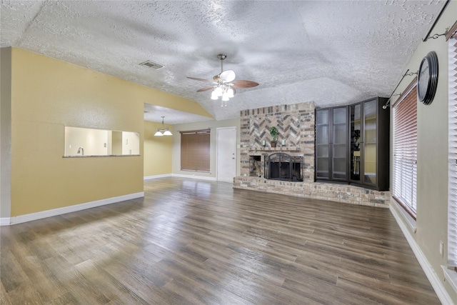 unfurnished living room with wood finished floors, a fireplace, visible vents, and a textured ceiling