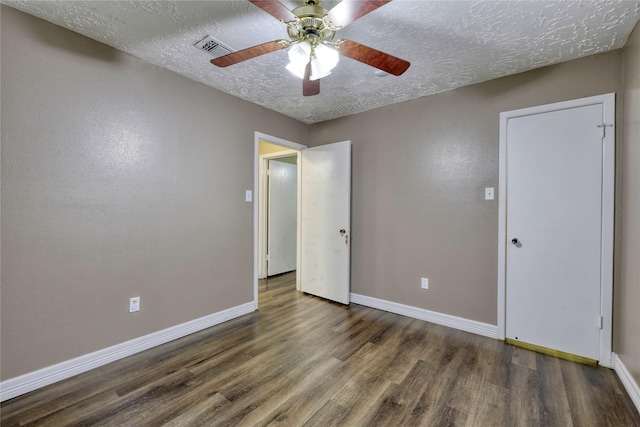 unfurnished bedroom with a ceiling fan, wood finished floors, visible vents, baseboards, and a textured ceiling