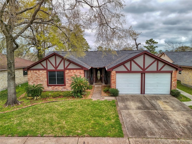 tudor house featuring roof with shingles, concrete driveway, a front yard, a garage, and brick siding