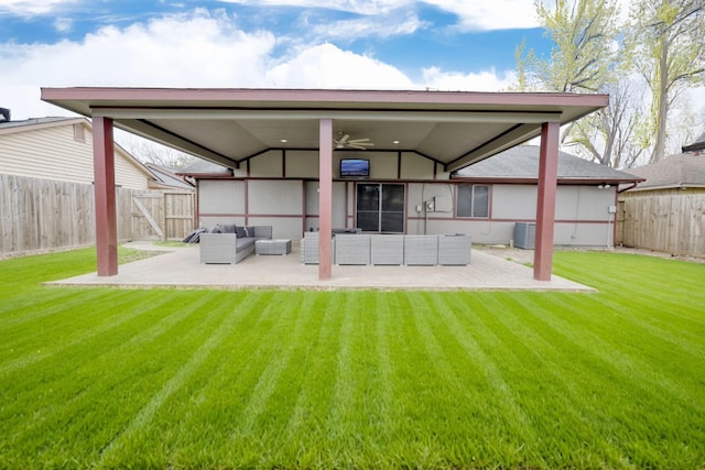 back of house with a fenced backyard, an outdoor living space, a lawn, and a patio