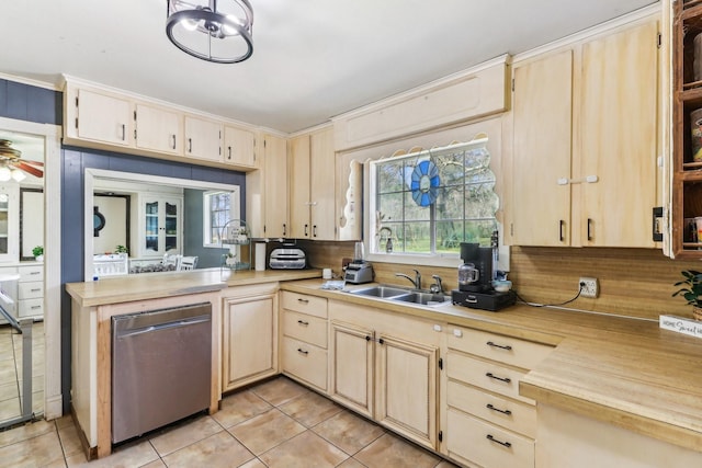 kitchen featuring dishwasher, light countertops, light tile patterned floors, and a sink