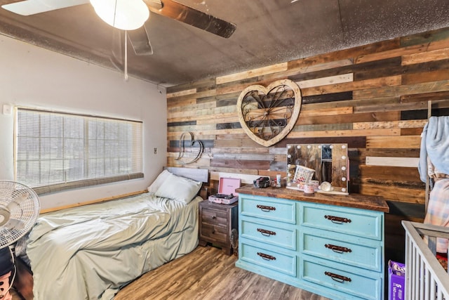 bedroom with wood finished floors and wood walls