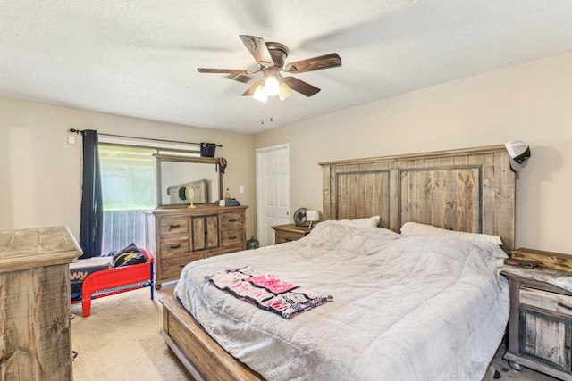 carpeted bedroom featuring a textured ceiling and ceiling fan