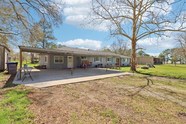 back of house with a yard and a patio