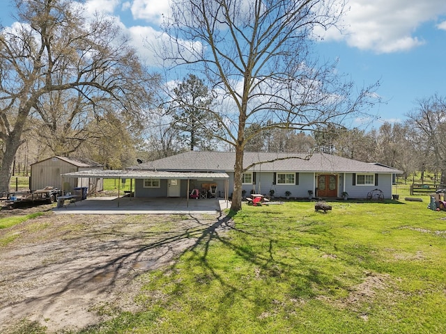 ranch-style home featuring a front lawn, a carport, and driveway