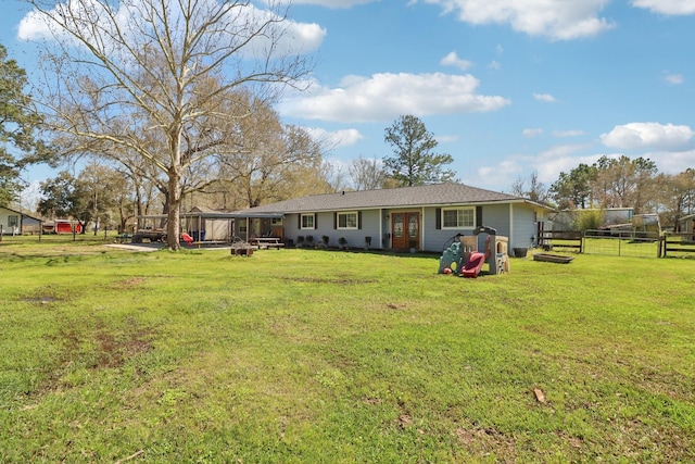 rear view of property with a lawn and fence