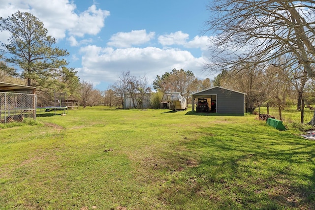 view of yard with an outbuilding, an outdoor structure, and a trampoline