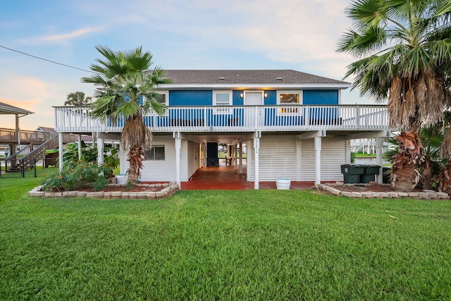 back of property at dusk with a lawn and a wooden deck