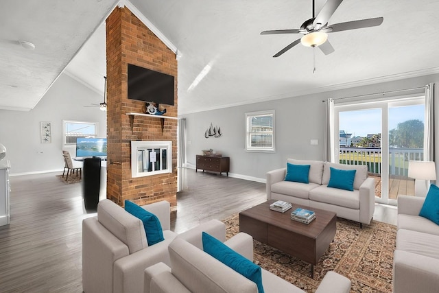 living area with a wealth of natural light, wood finished floors, ornamental molding, and vaulted ceiling