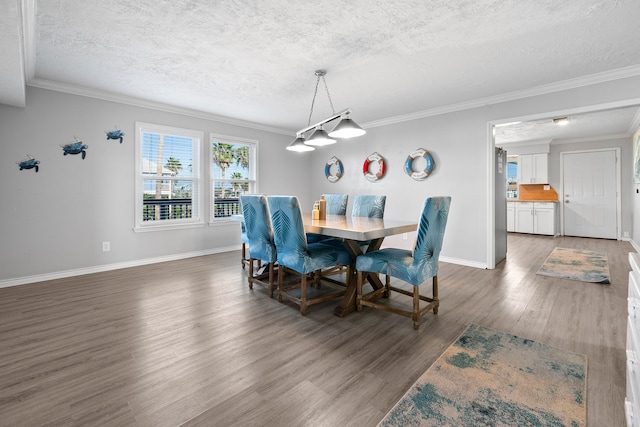 dining space with a textured ceiling, crown molding, and wood finished floors