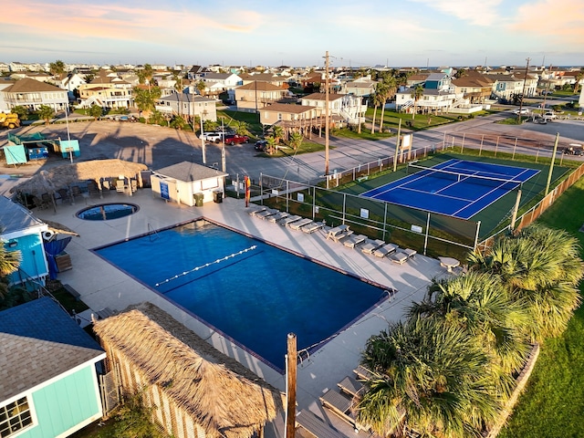 view of swimming pool featuring a residential view, a tennis court, and fence