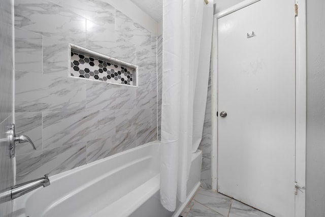 bathroom featuring shower / bath combo with shower curtain and marble finish floor