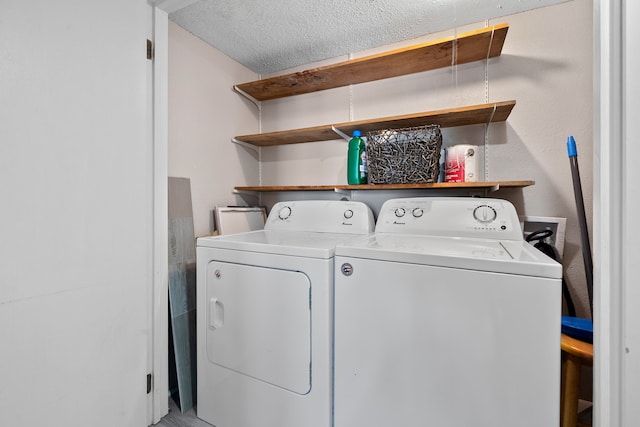 washroom featuring laundry area, independent washer and dryer, and a textured ceiling