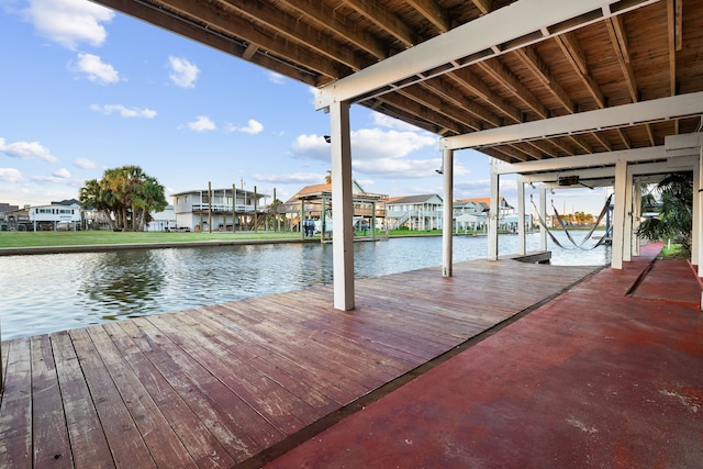 view of dock with a residential view and a water view