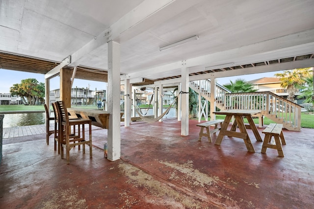 view of patio with boat lift, stairway, and a dock