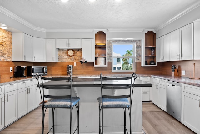 kitchen with open shelves, white cabinets, and appliances with stainless steel finishes