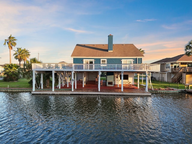 back of house featuring a water view and a chimney