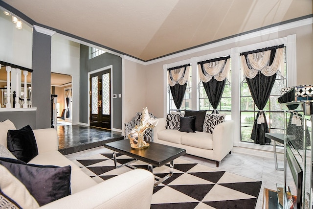 living room with marble finish floor, crown molding, baseboards, and vaulted ceiling