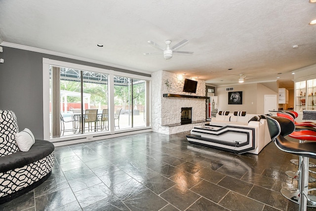 living room with a textured ceiling, a stone fireplace, ceiling fan, and crown molding