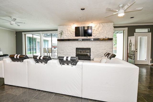 living room featuring a fireplace, crown molding, and a ceiling fan