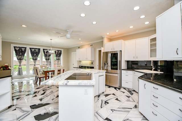 kitchen featuring a kitchen island, a sink, white cabinets, stainless steel refrigerator with ice dispenser, and backsplash