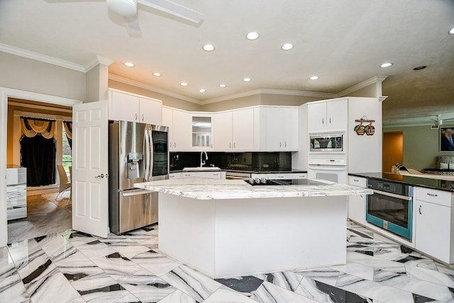 kitchen with marble finish floor, a sink, a kitchen island, appliances with stainless steel finishes, and white cabinets