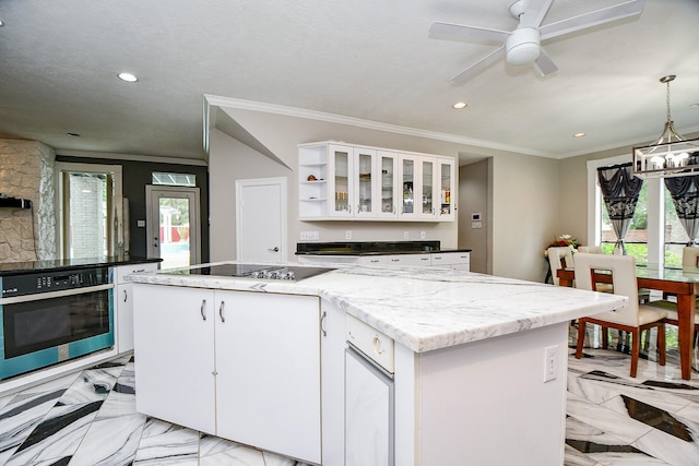 kitchen featuring stainless steel oven, black electric stovetop, a kitchen island, and crown molding