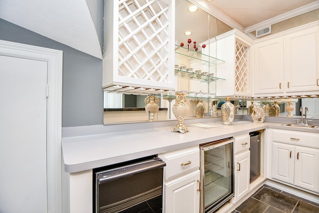 kitchen featuring a sink, visible vents, wine cooler, and light countertops